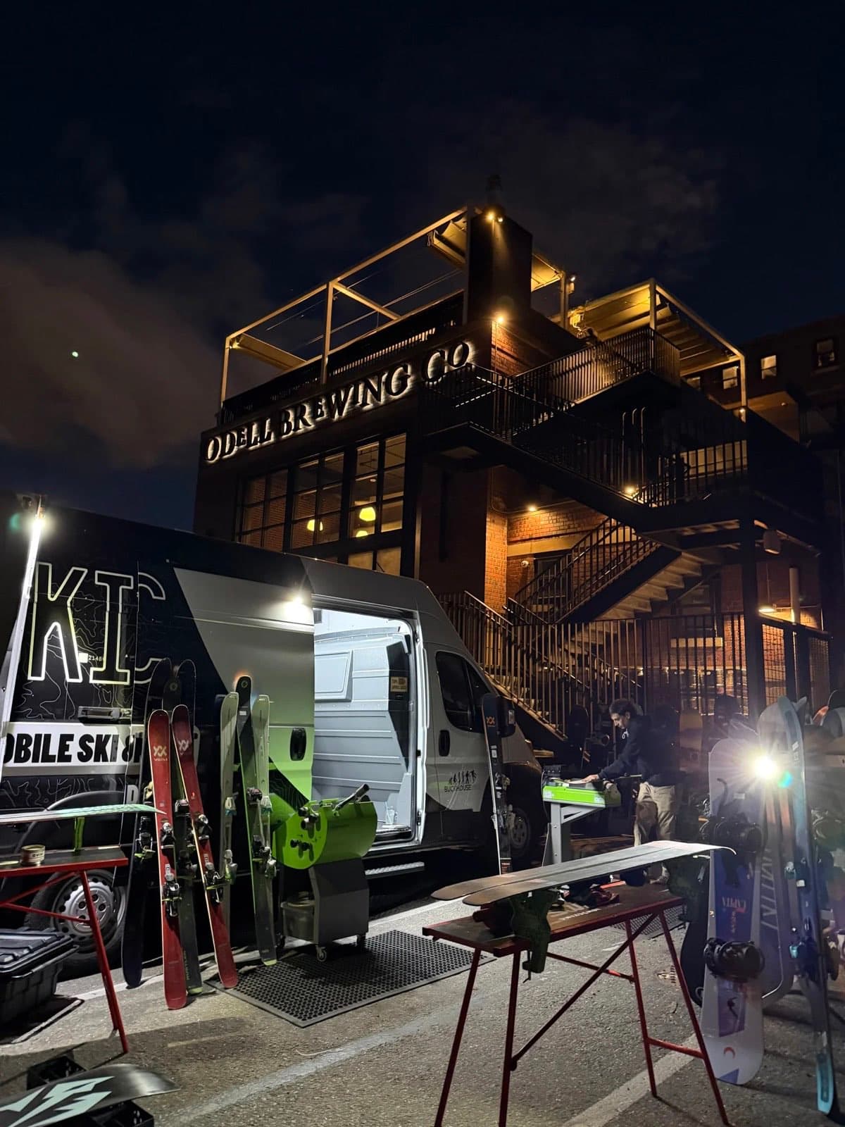 Evening Brewery Day wax event outside a taproom with skis and snowboards on racks