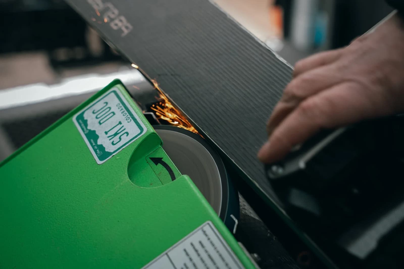 Sparks flying off a ski edge on a professional grinding machine